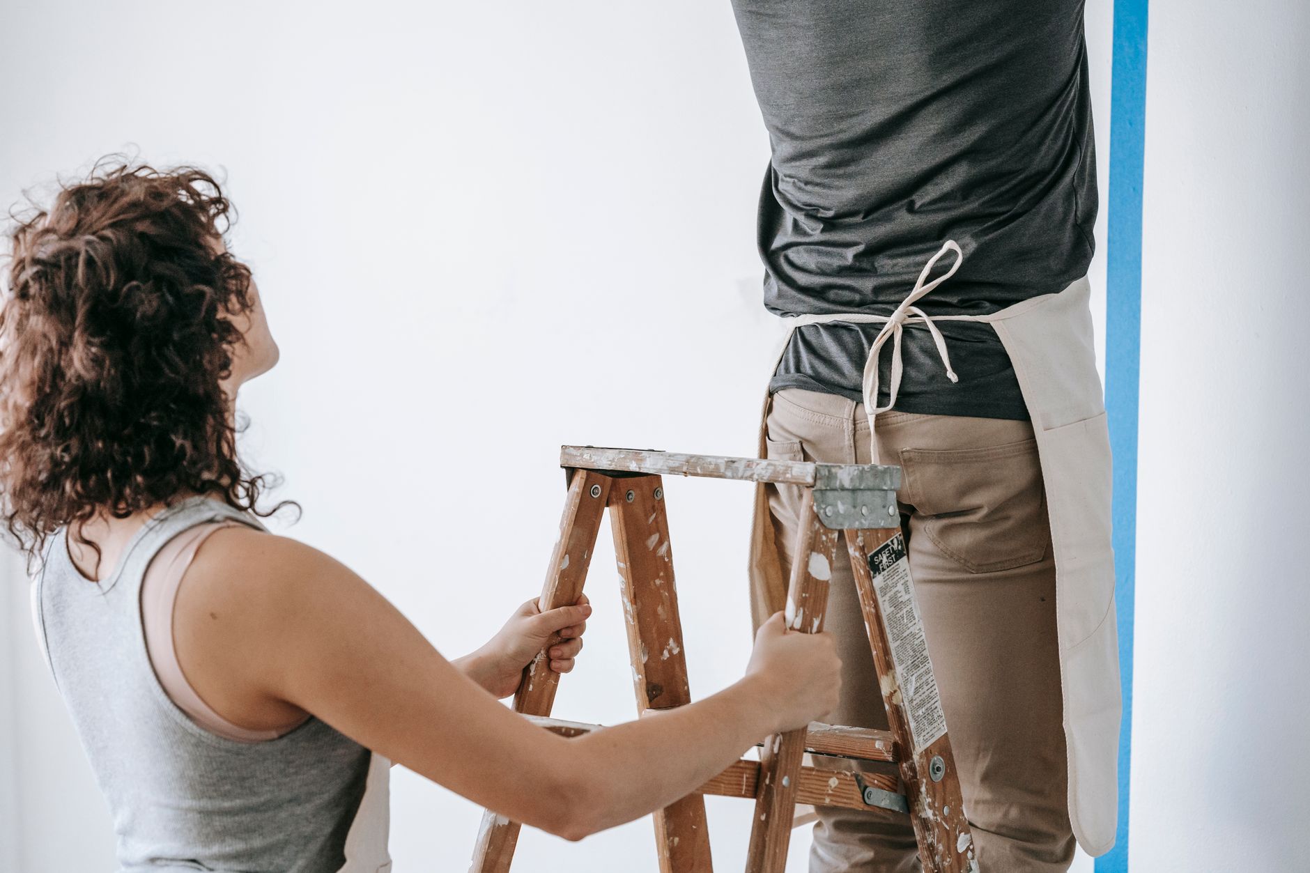 Couple working together to paint a wall during home renovation, featuring teamwork and DIY spirit in Torrance, CA